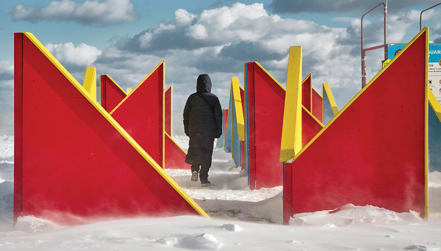 A person standing in front of a red and yellow structure.