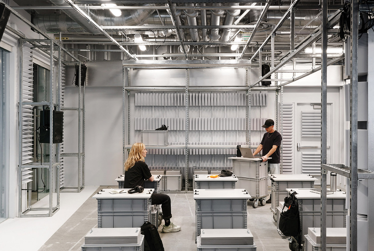 A couple of people working in a large room.