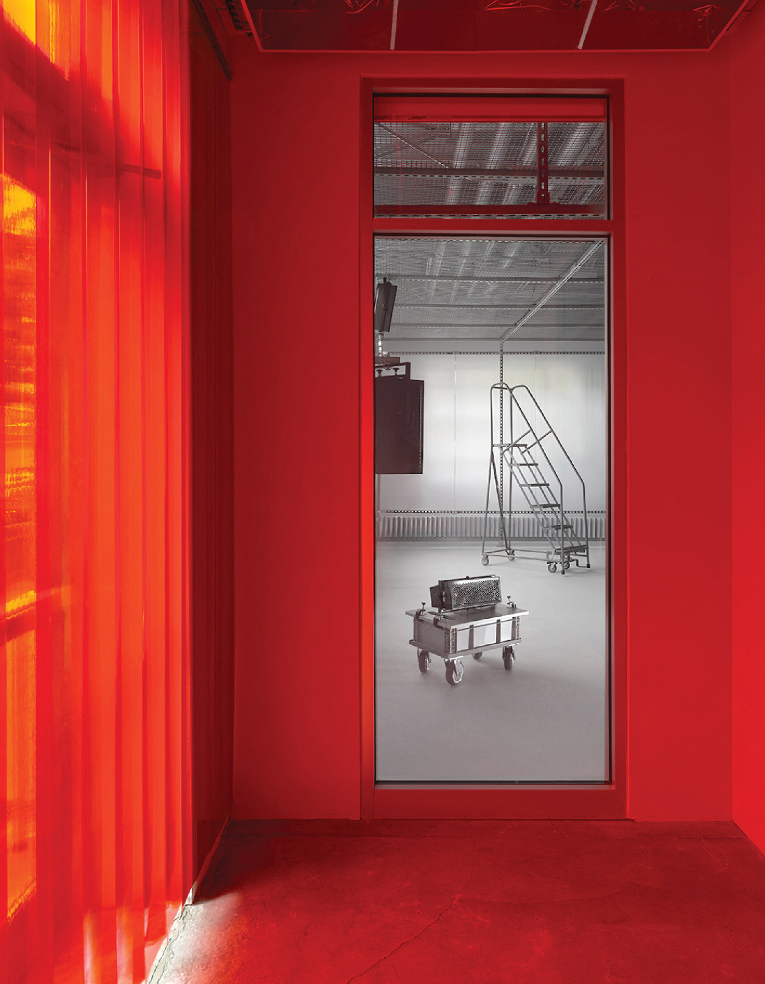 A red room with a red wall and a white chair.