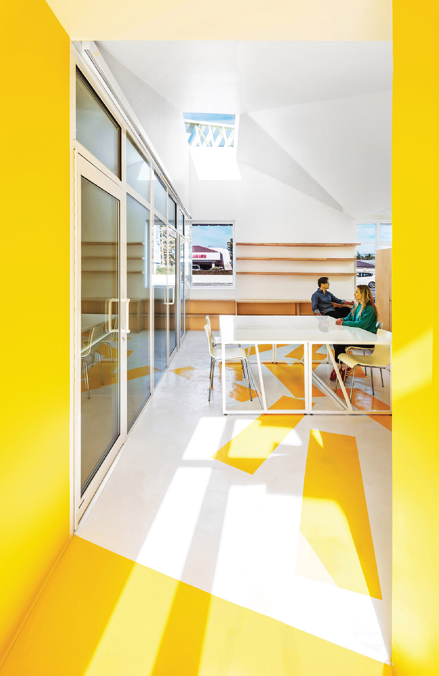 A yellow room with a white table and chairs.