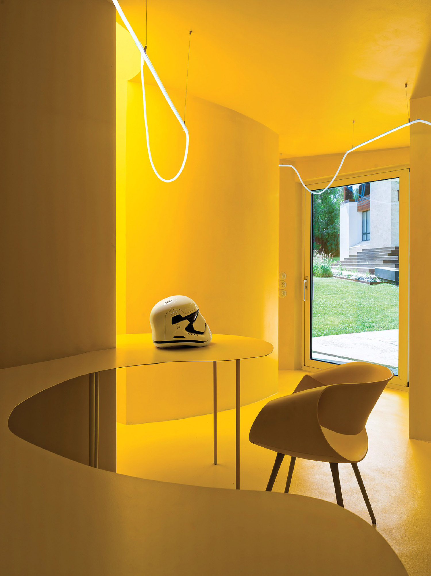 A chair and table in a room with a yellow light.