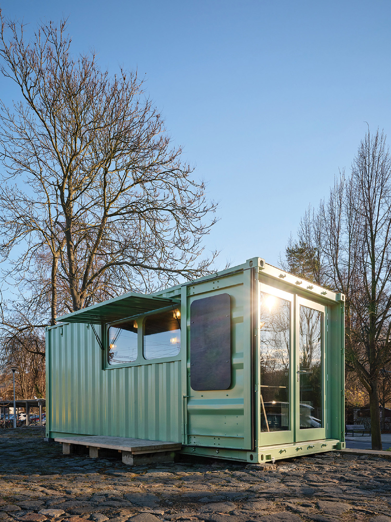 A green container sitting on the ground.
