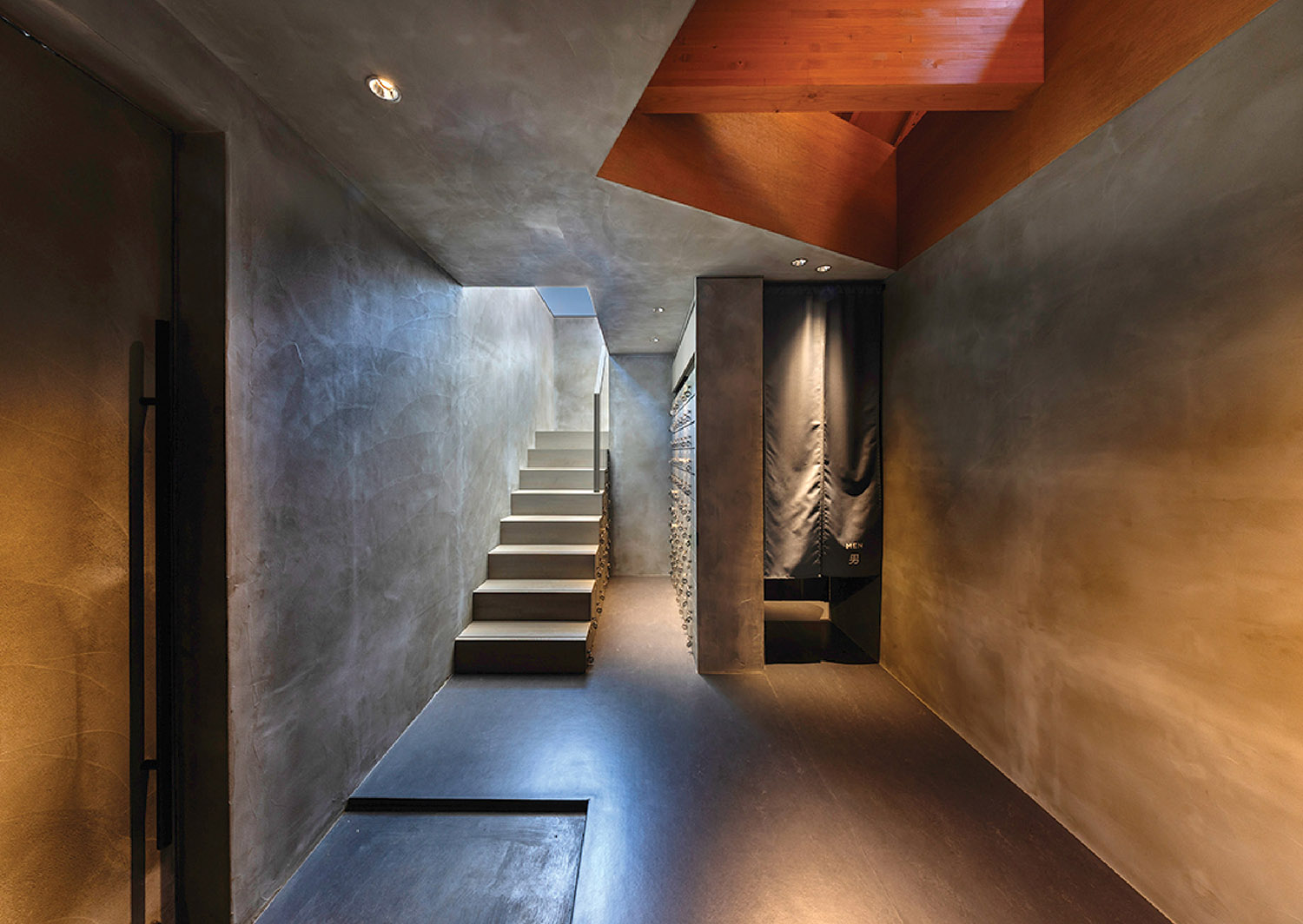 A long hallway with a wooden ceiling and a staircase.