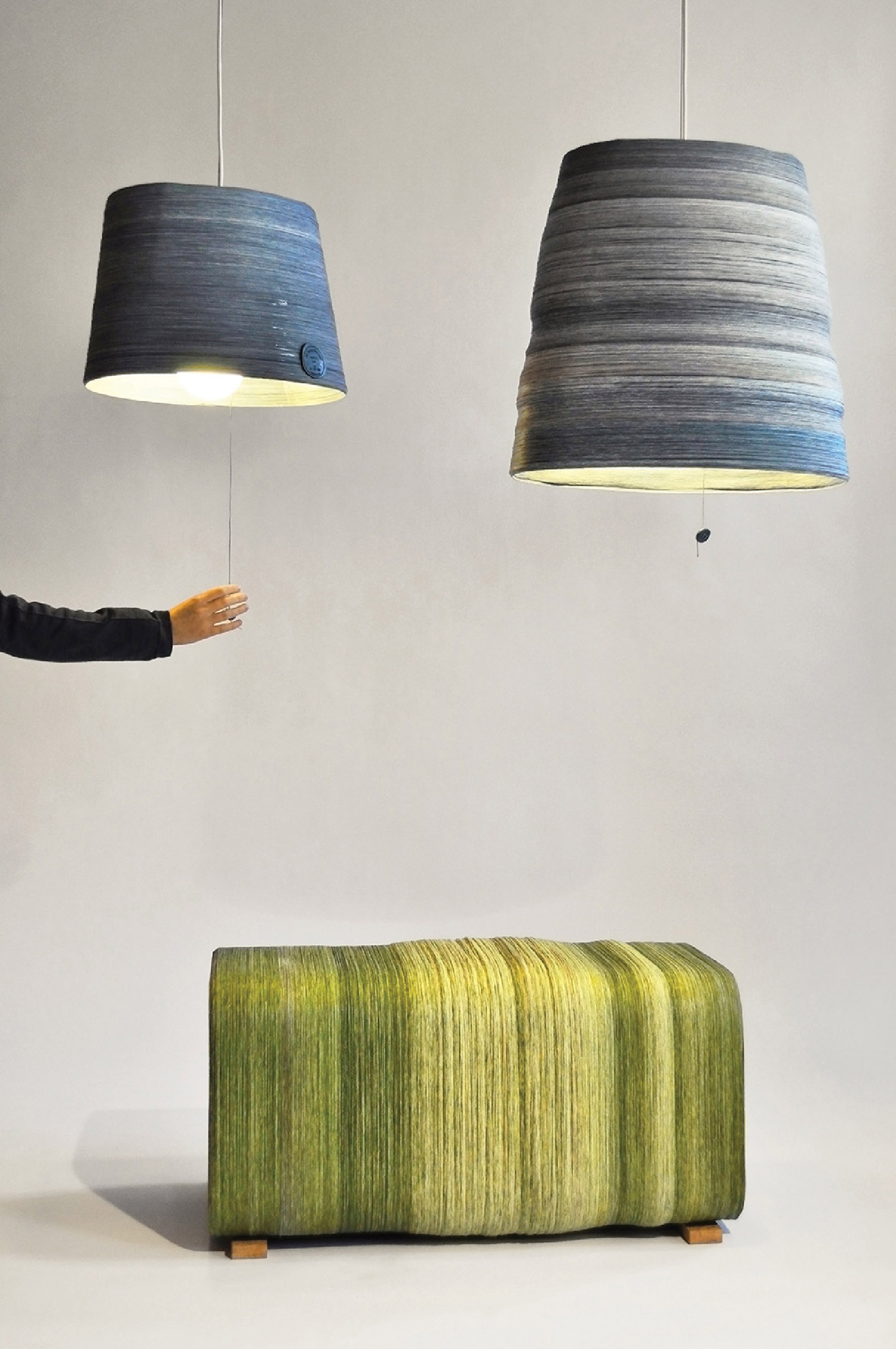 A man pointing at a large green and blue lamp.
