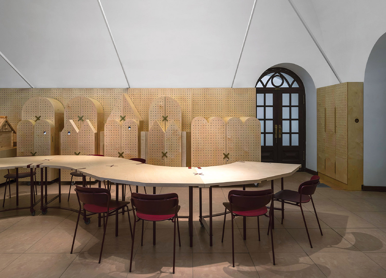 A room with a table and chairs and a wall with a pattern.