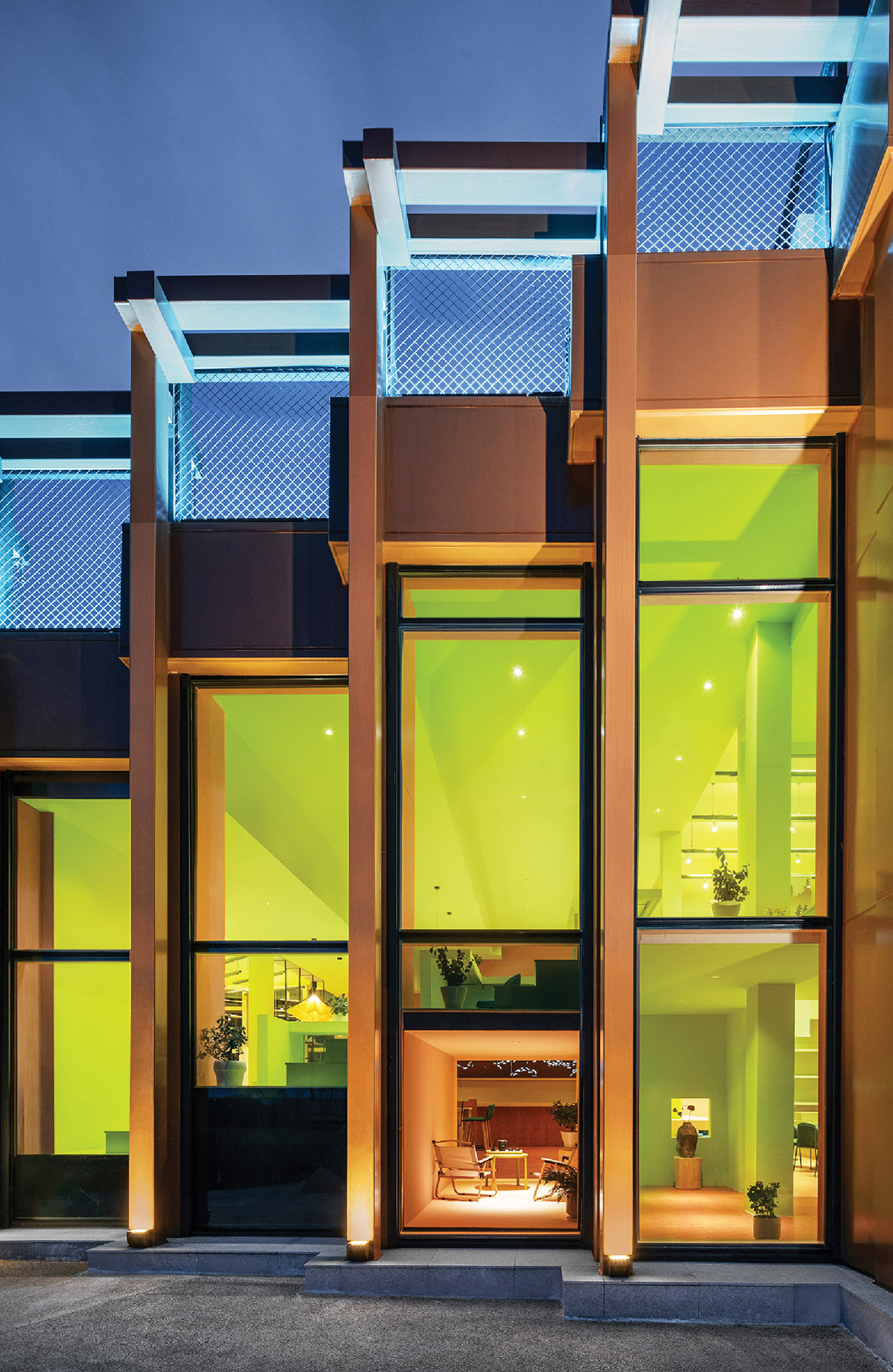 A modern house with a glass wall and a fireplace.