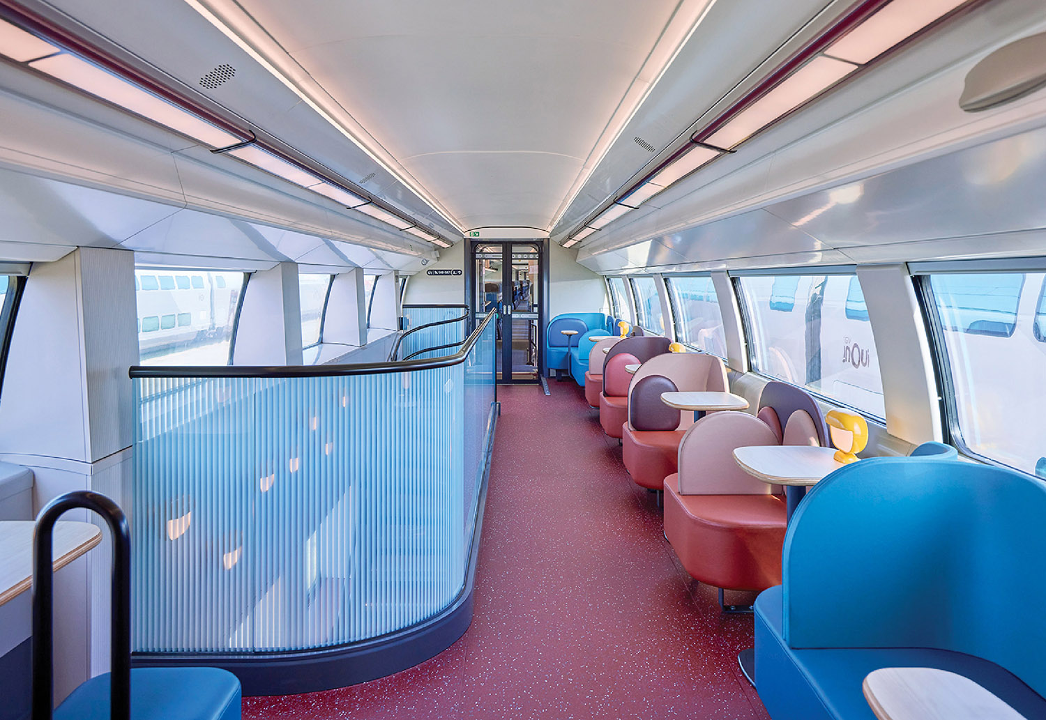 A train car with a lot of seats and a table.