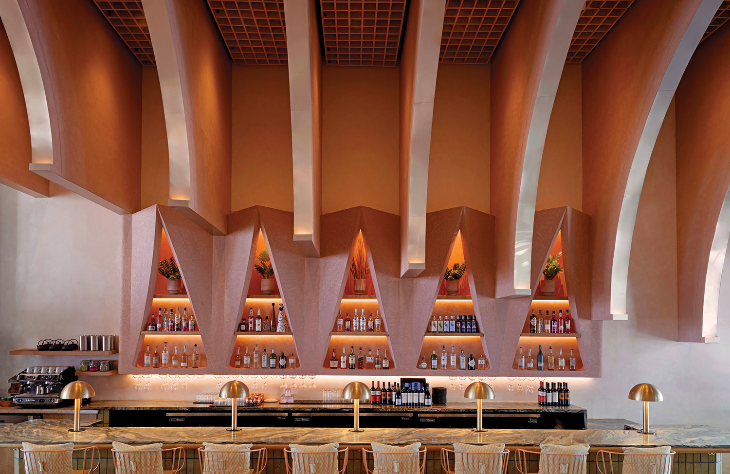 A bar with a lot of bottles on the wall.