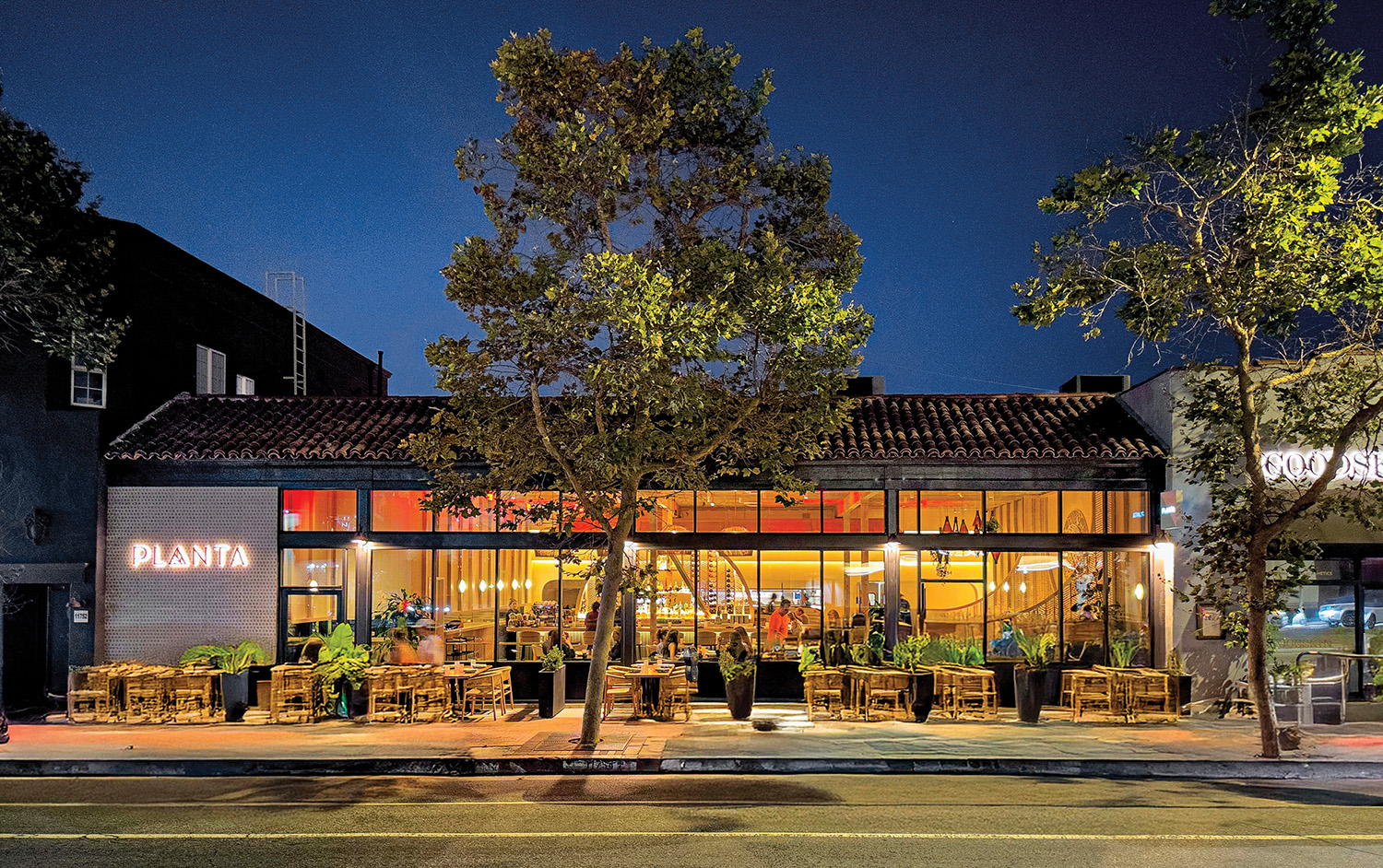 A restaurant with a tree in front of it.