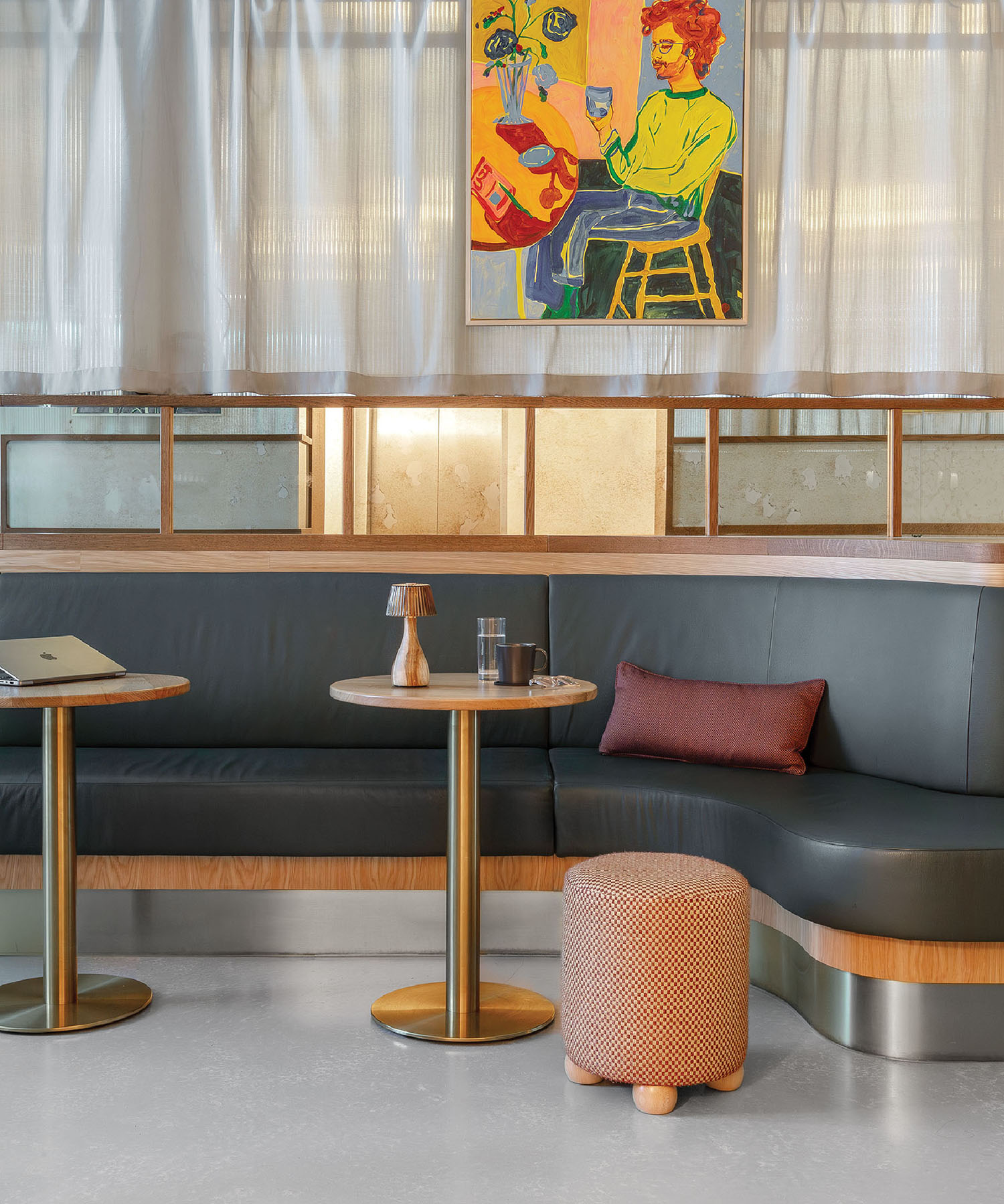 A couch and table in a room with a painting on the wall.