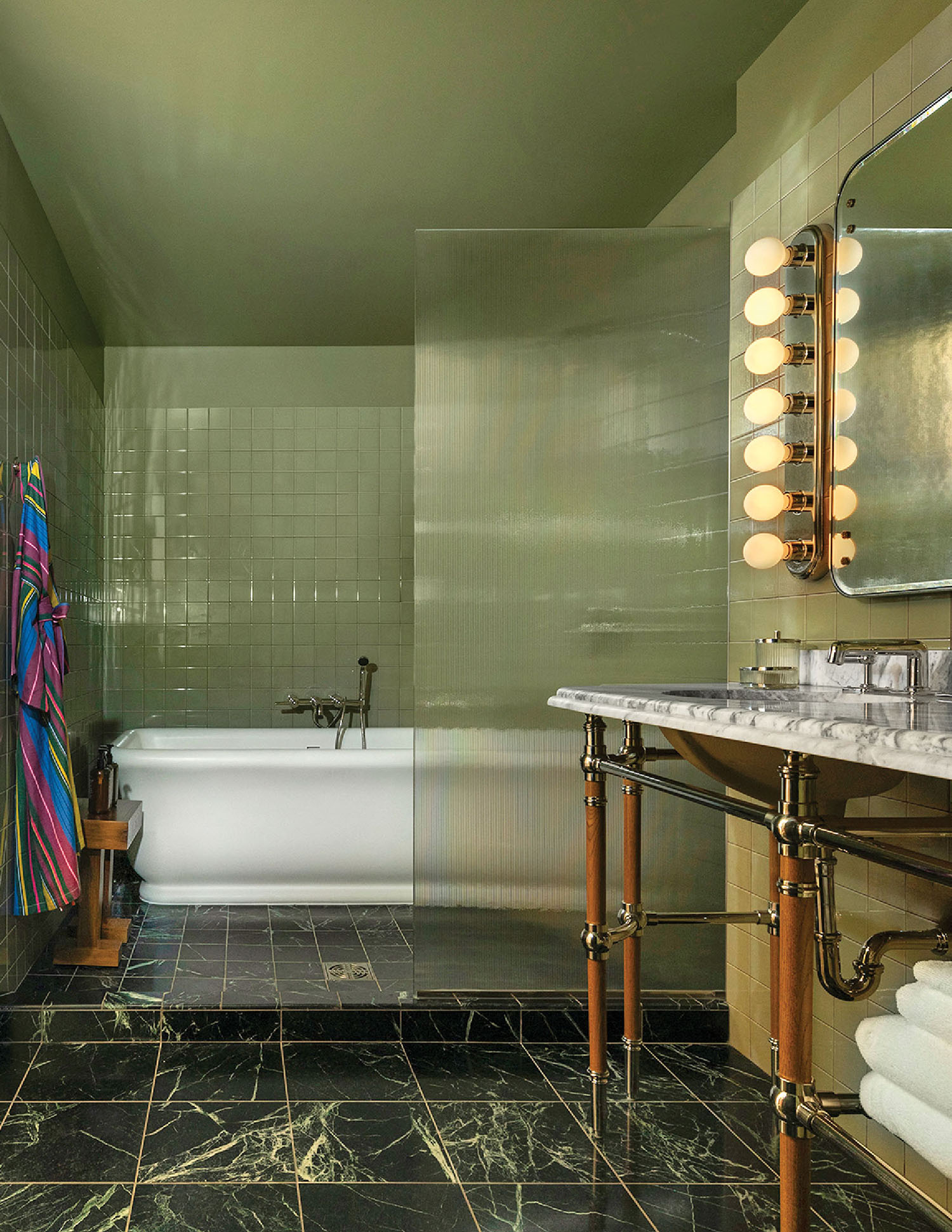 A bathroom with a marble floor and a tub.