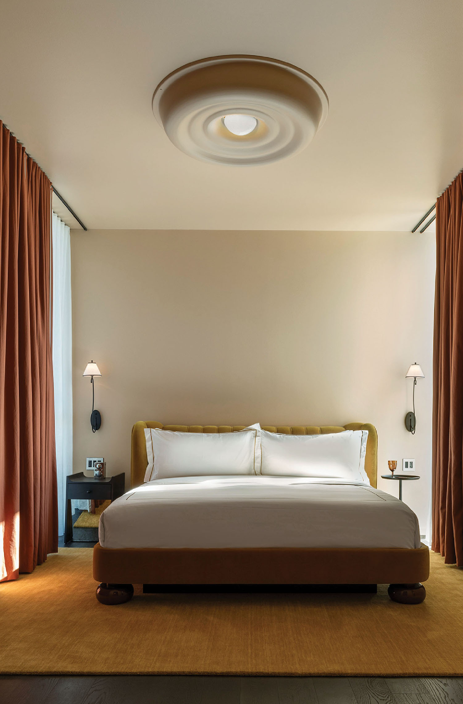 A bed with a white comforter and a brown headboard.