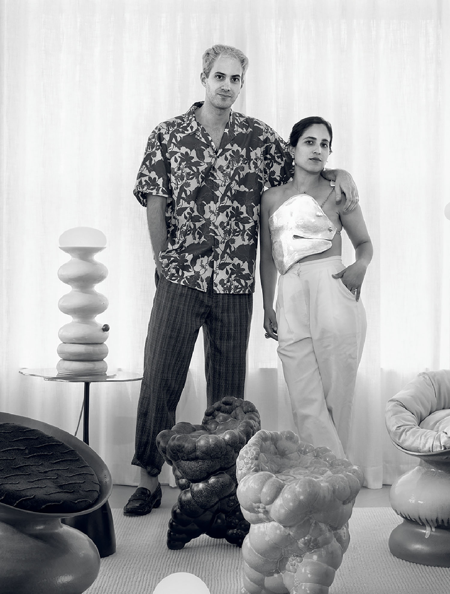 A man and woman standing in a room with a bunch of stuffed anima.