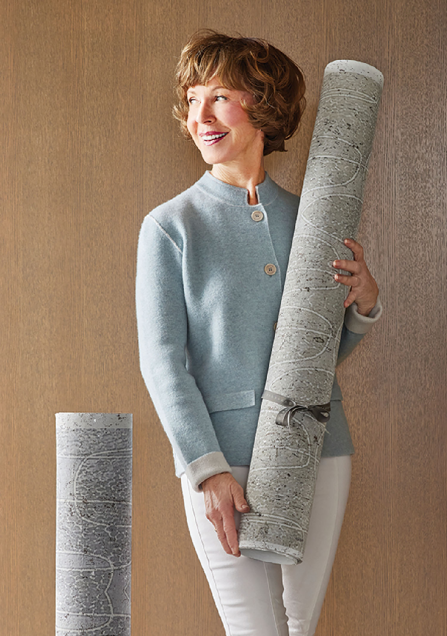 A woman holding a large roll of paper.