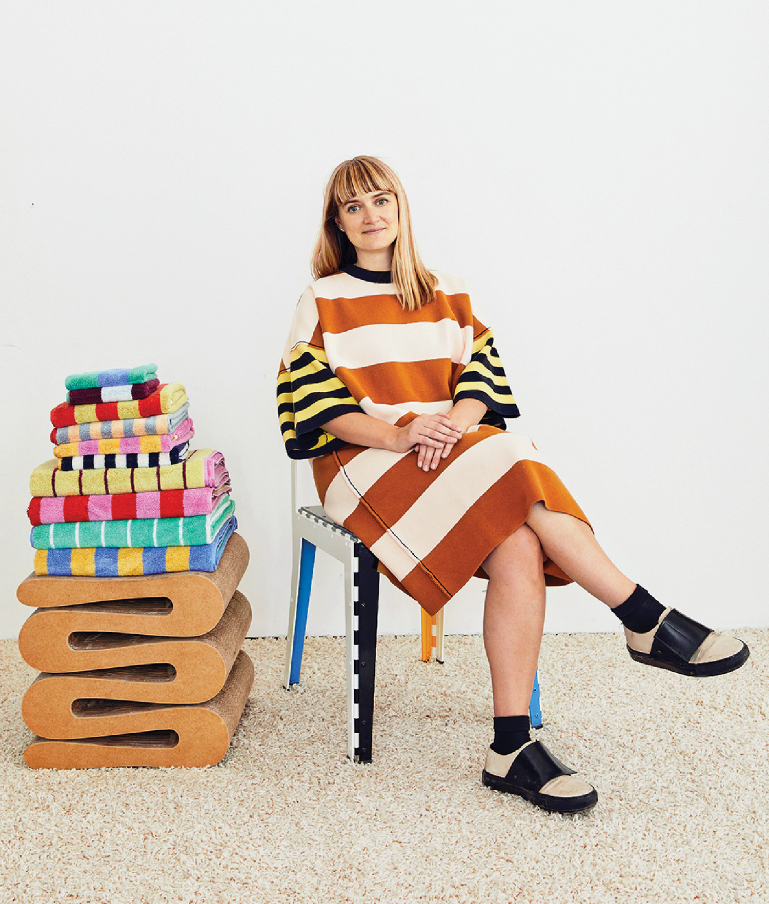 A woman sitting on a chair with a stack of books