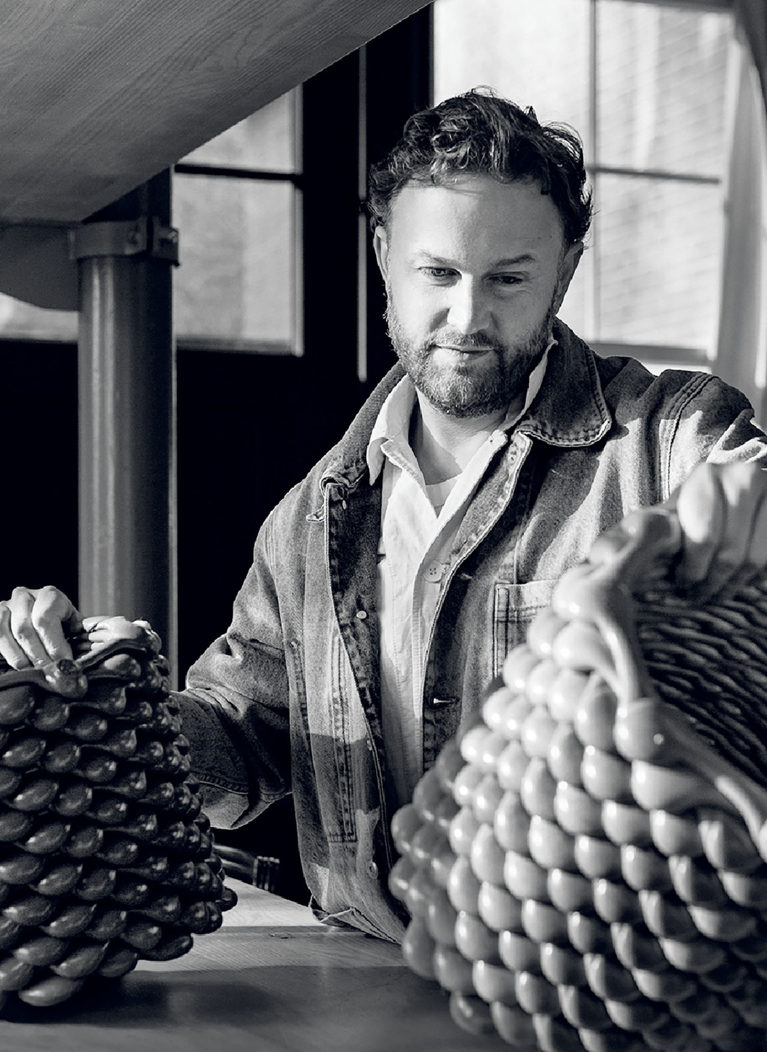 A man is standing at a table with bananas.