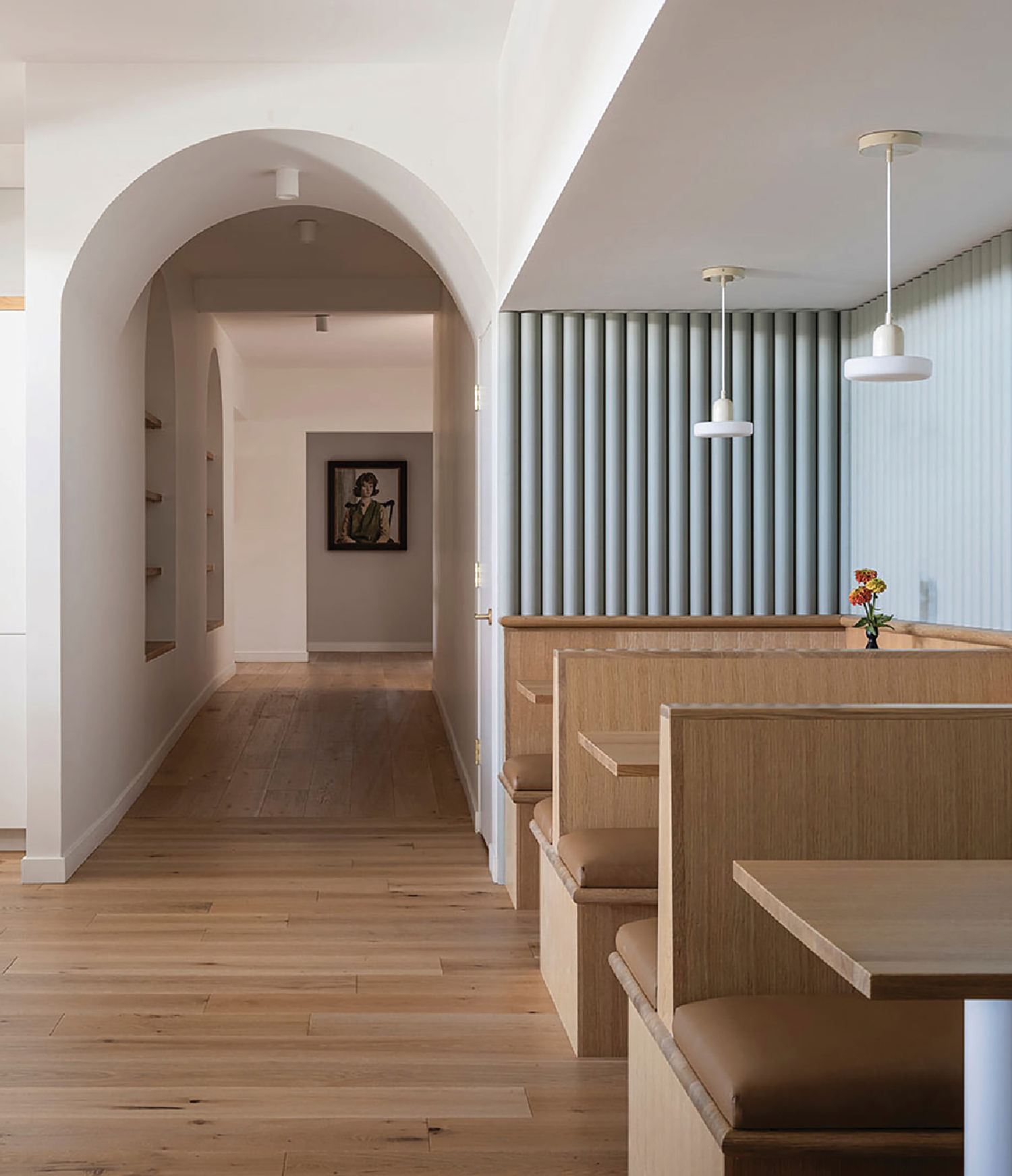 A long hallway with wooden floors and white walls.