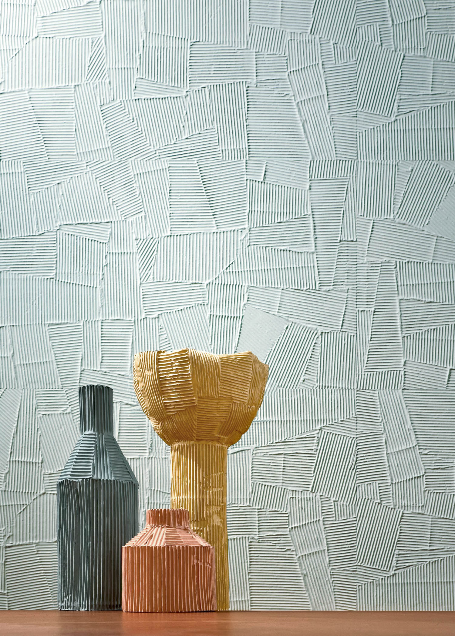 ceramic vases in front of textural tiles