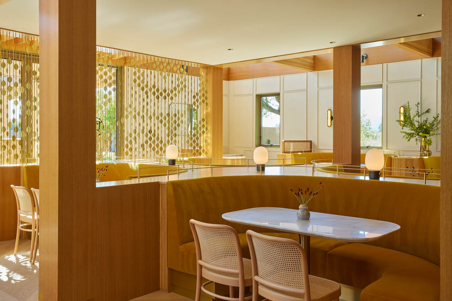 seating nook inside winery with bamboo cane chairs and curved booth