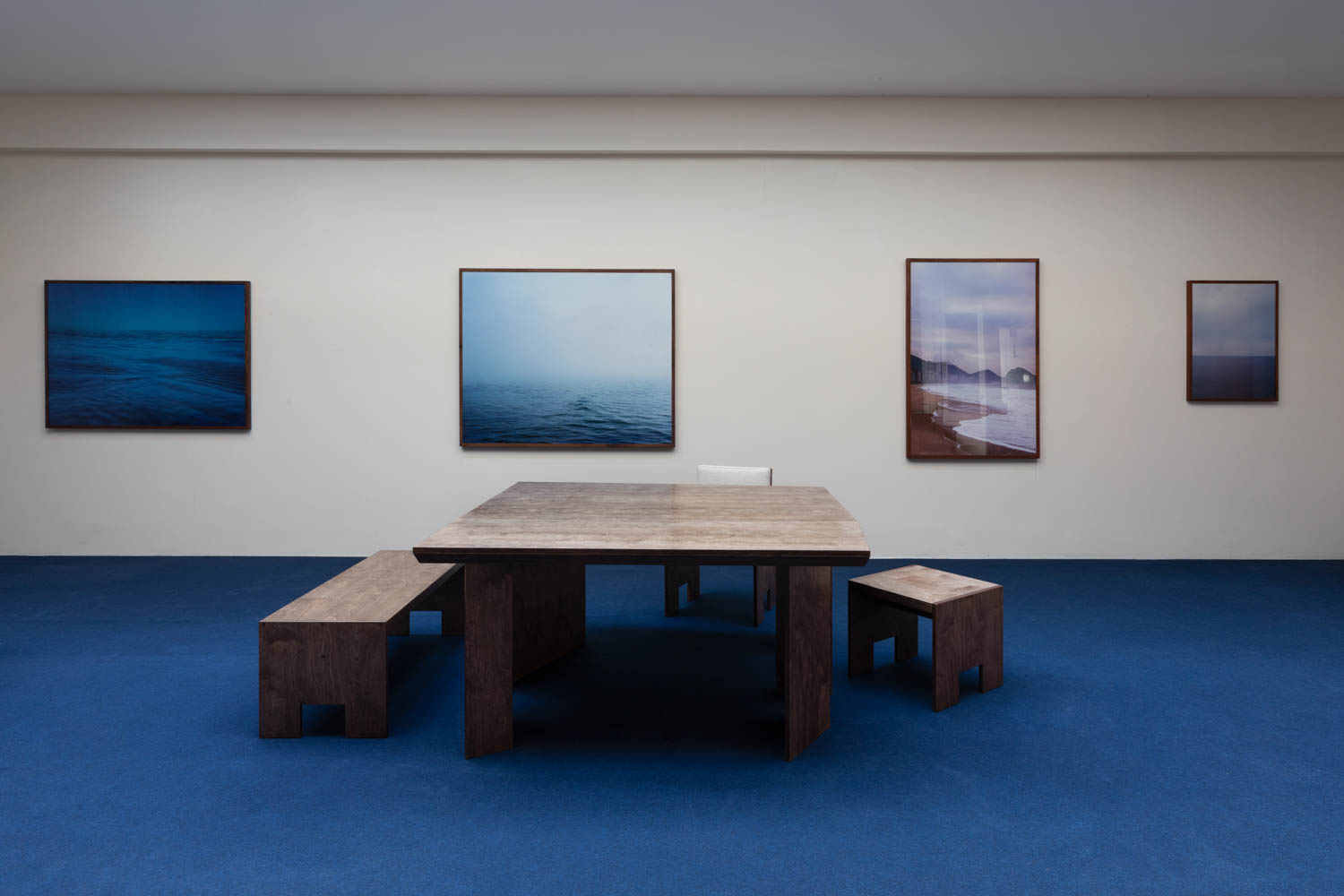 room with blue carpet, wooden furnishings and paintings