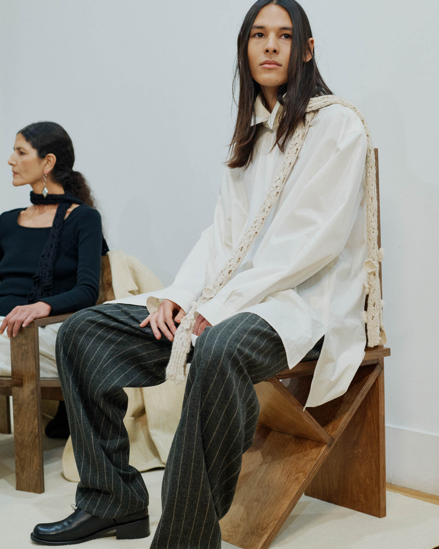 two people sitting on wooden chairs