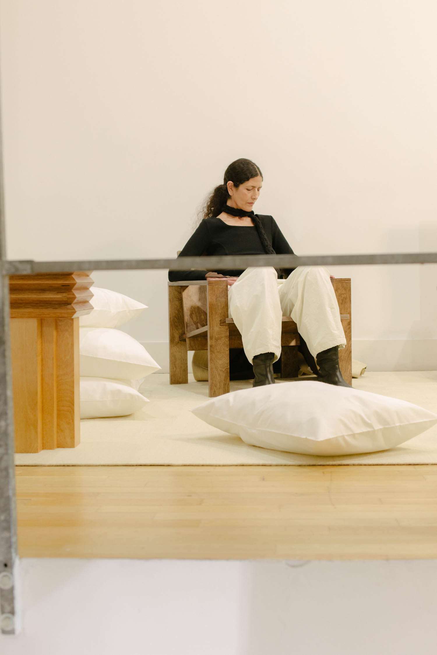 woman sitting on wooden chair next to pillows
