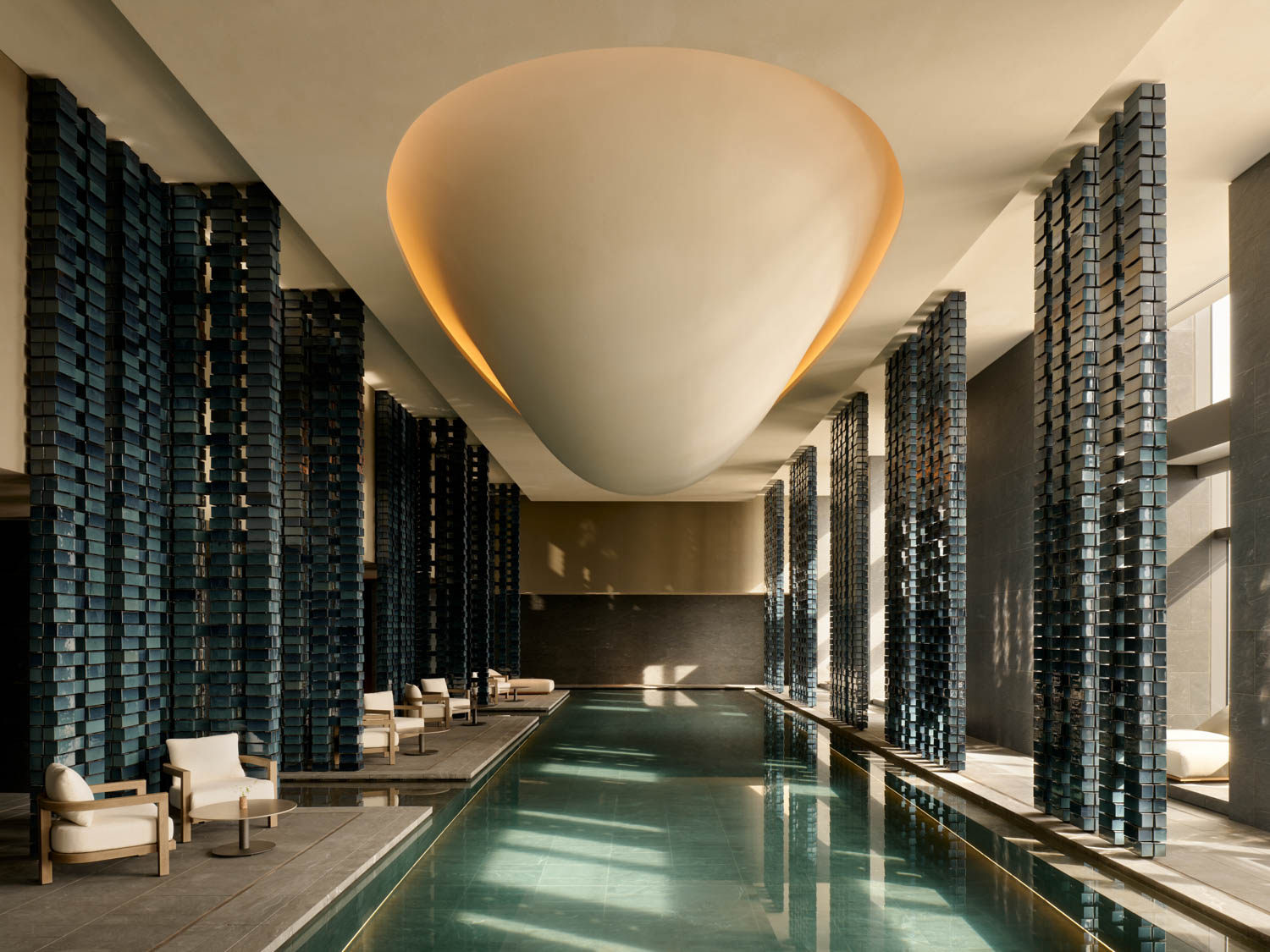pool with dark columns and large sculptural light
