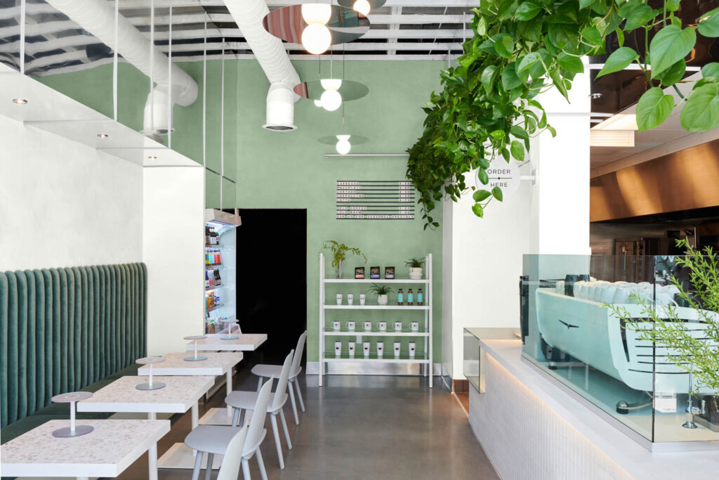 coffee shop interior with pastel green wall and greenery