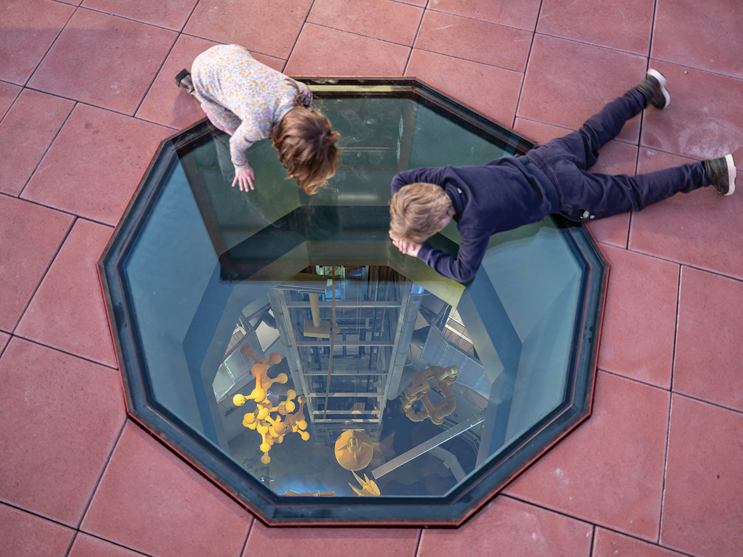 two people overlooking a floor window with a view of the inside