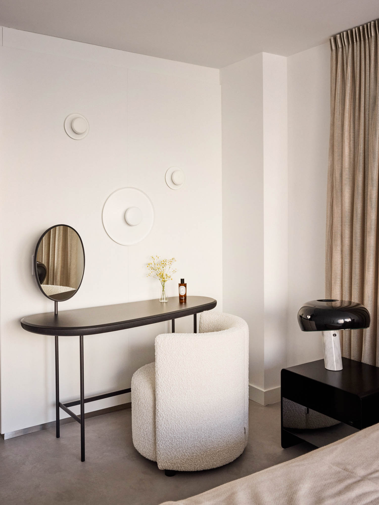 primary bedroom with white sconces and white chair
