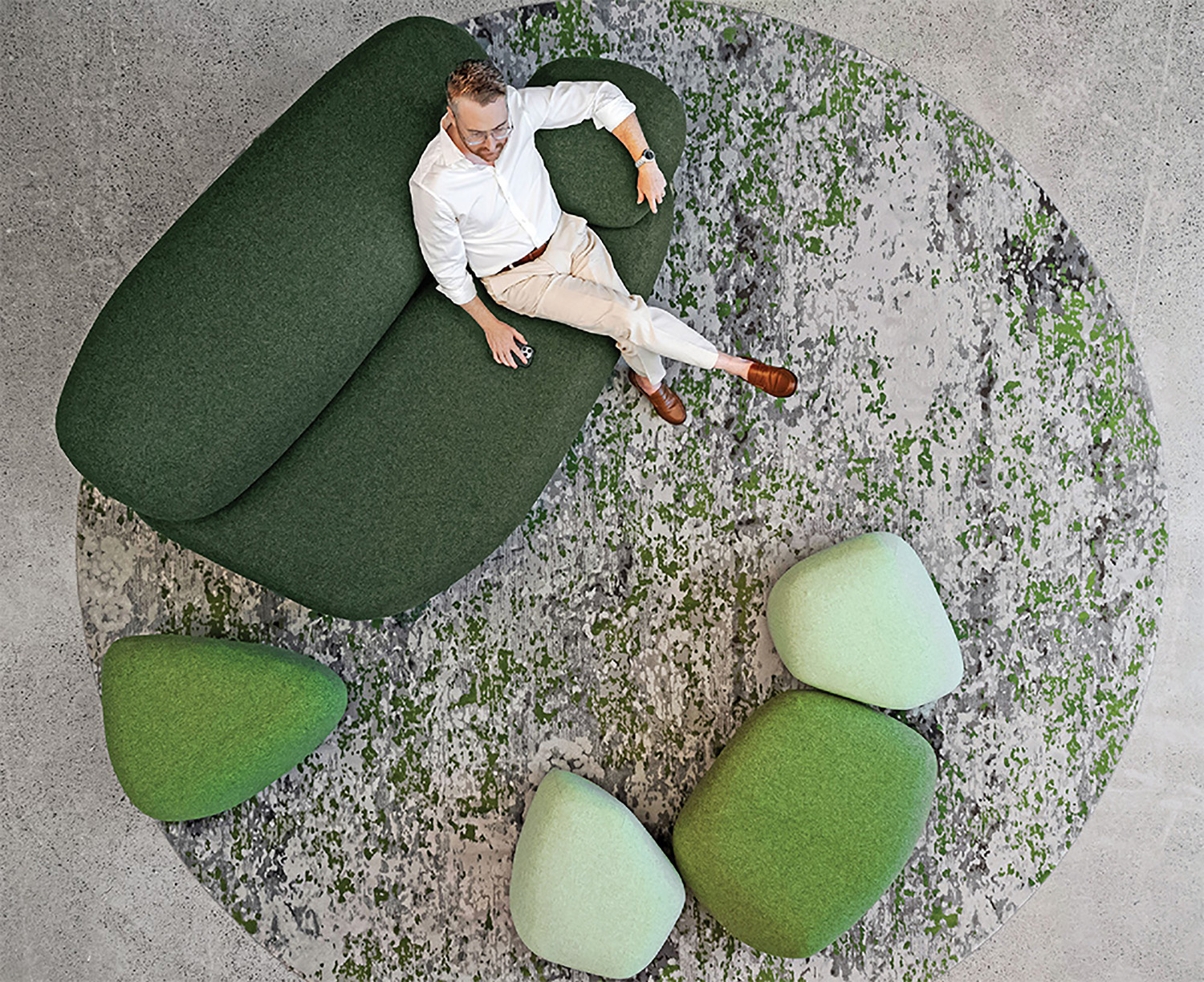 A man laying on a green couch.