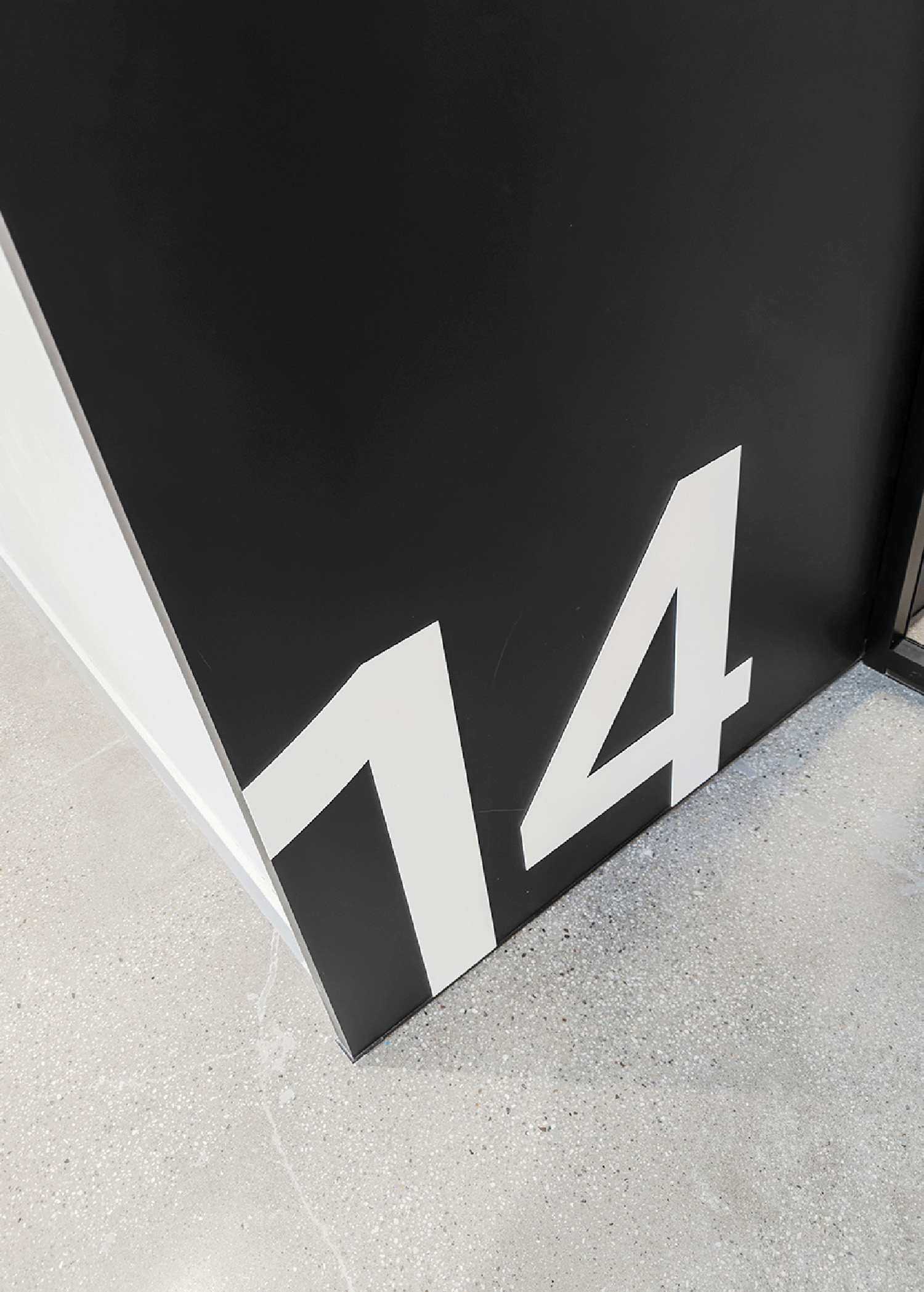 A black and white door with a number 14 on it.