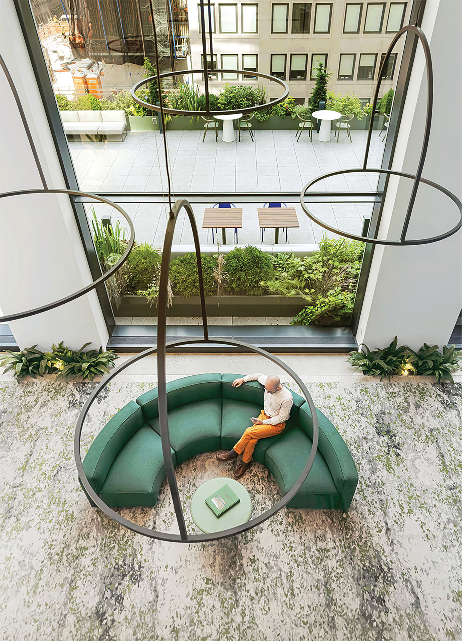 A man sitting on a green couch in a room.