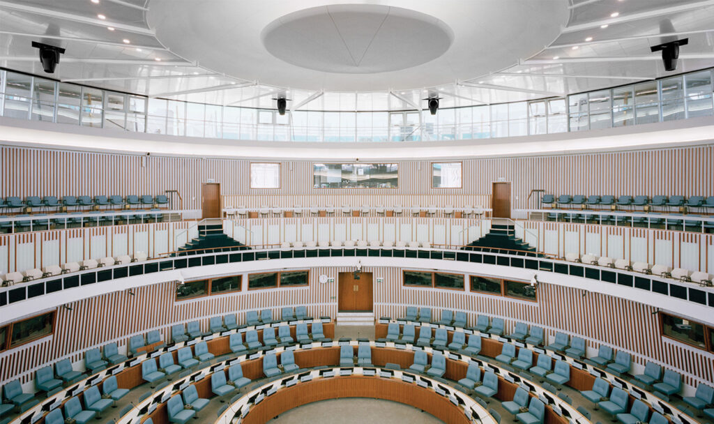 A large room with a circular table and chairs.