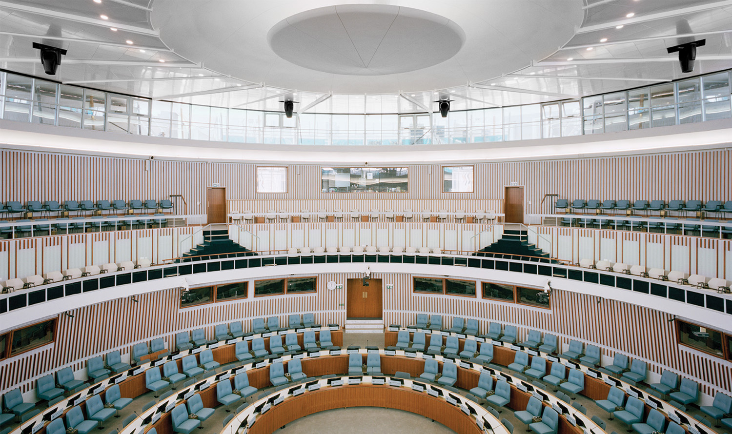 A large room with a circular table and chairs.