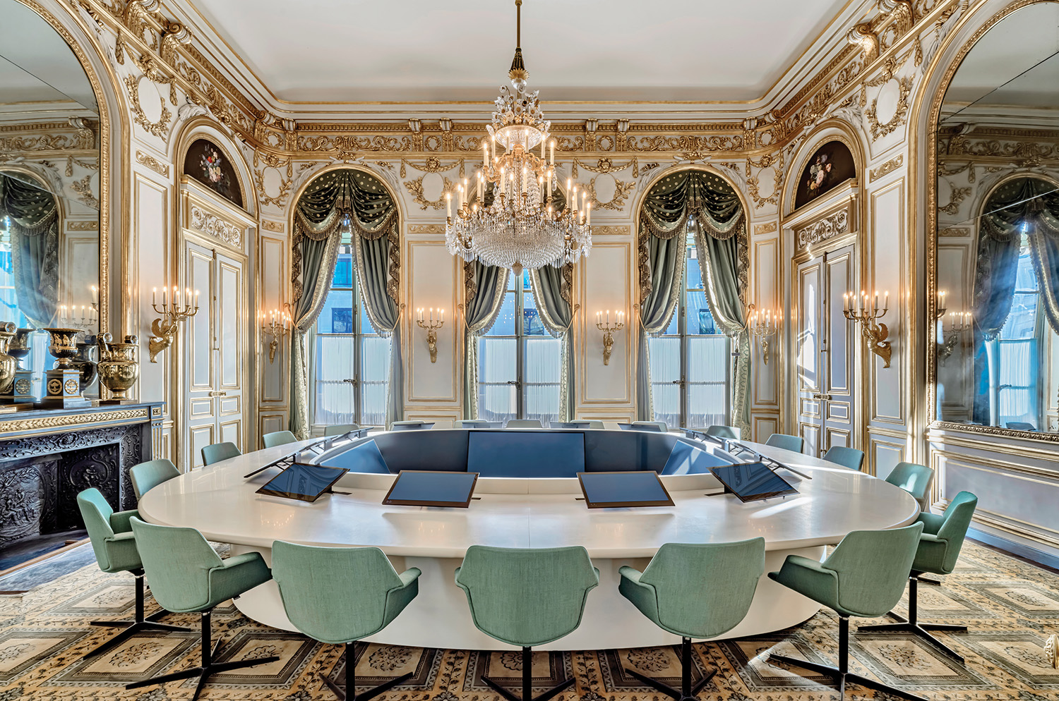 A dining room with a large table and chairs.