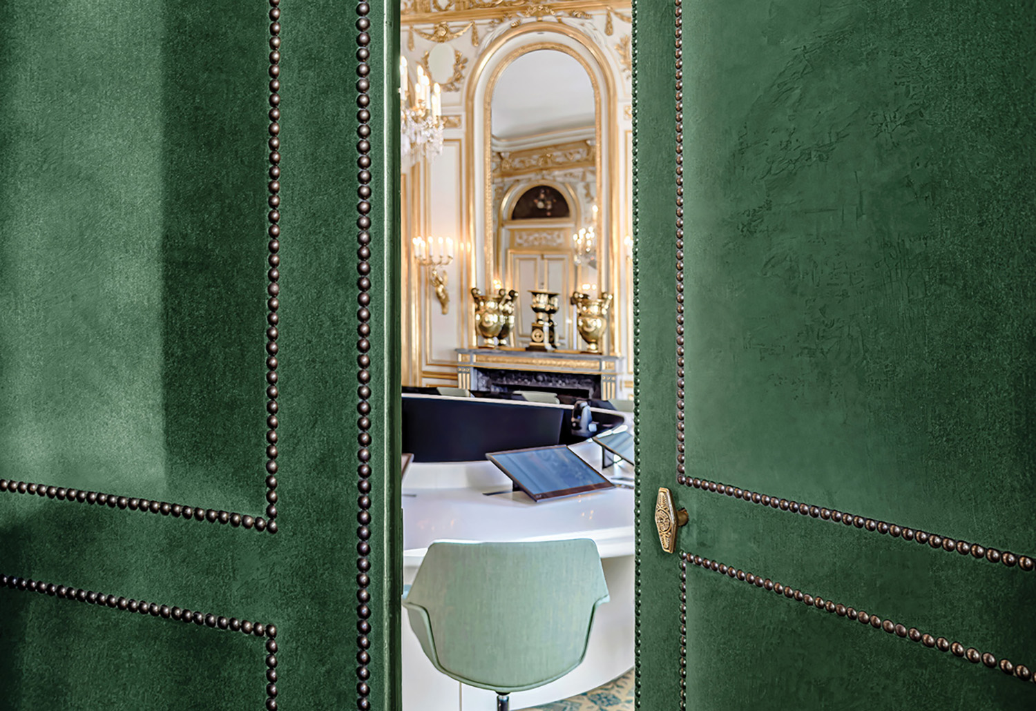 A green room with a mirror and a chair.