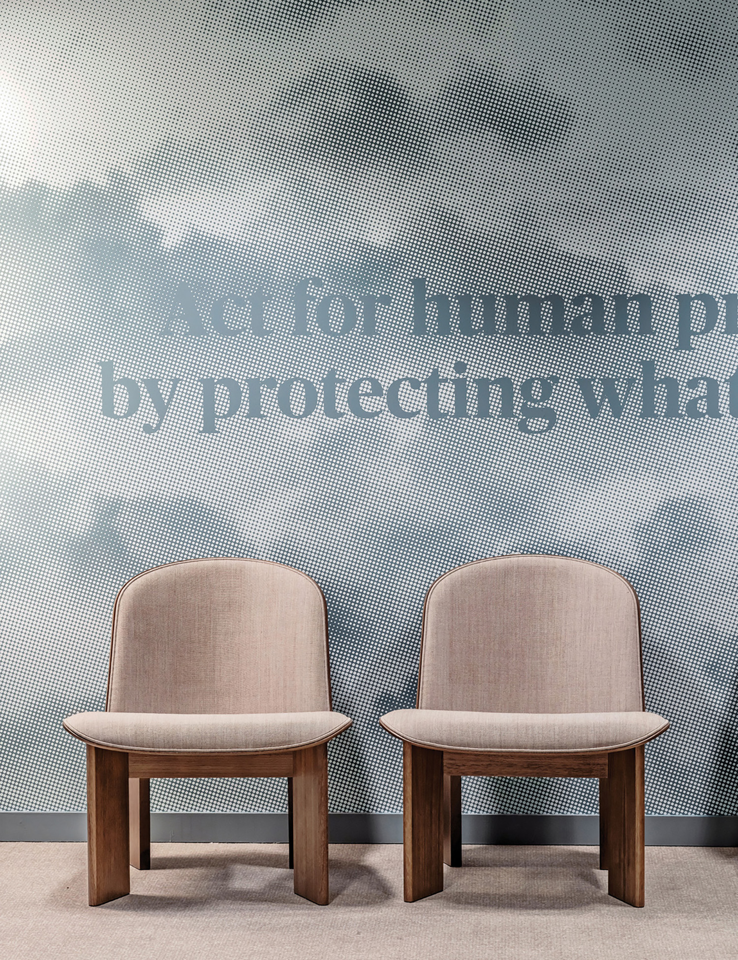 Two chairs in front of a wall with a quote.