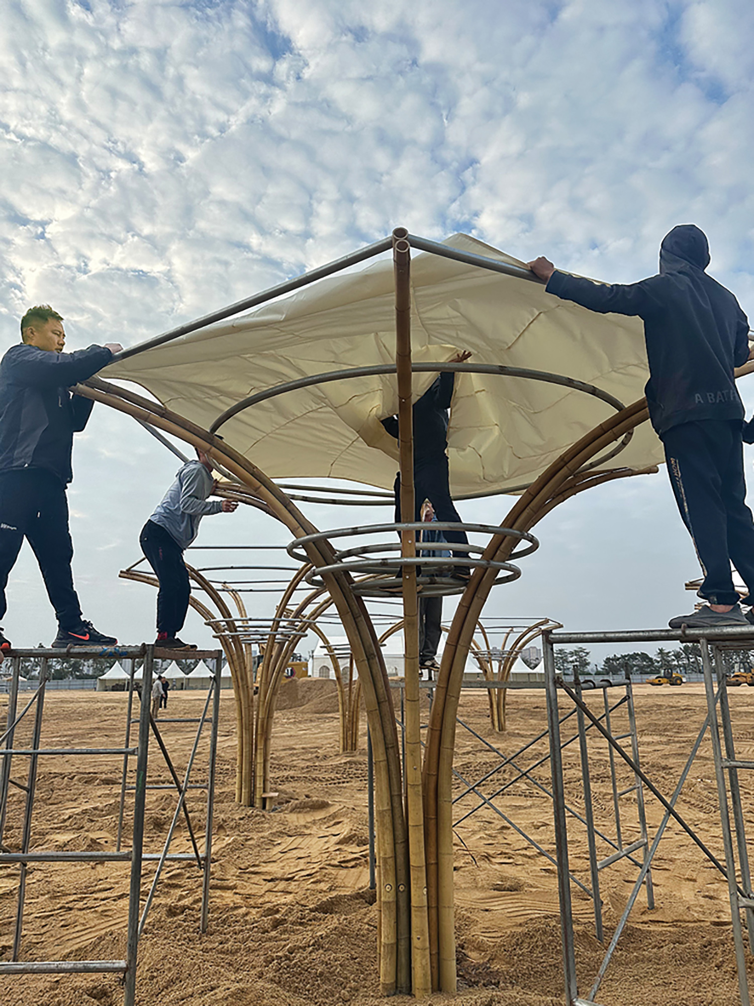 people putting cloth over a canopy