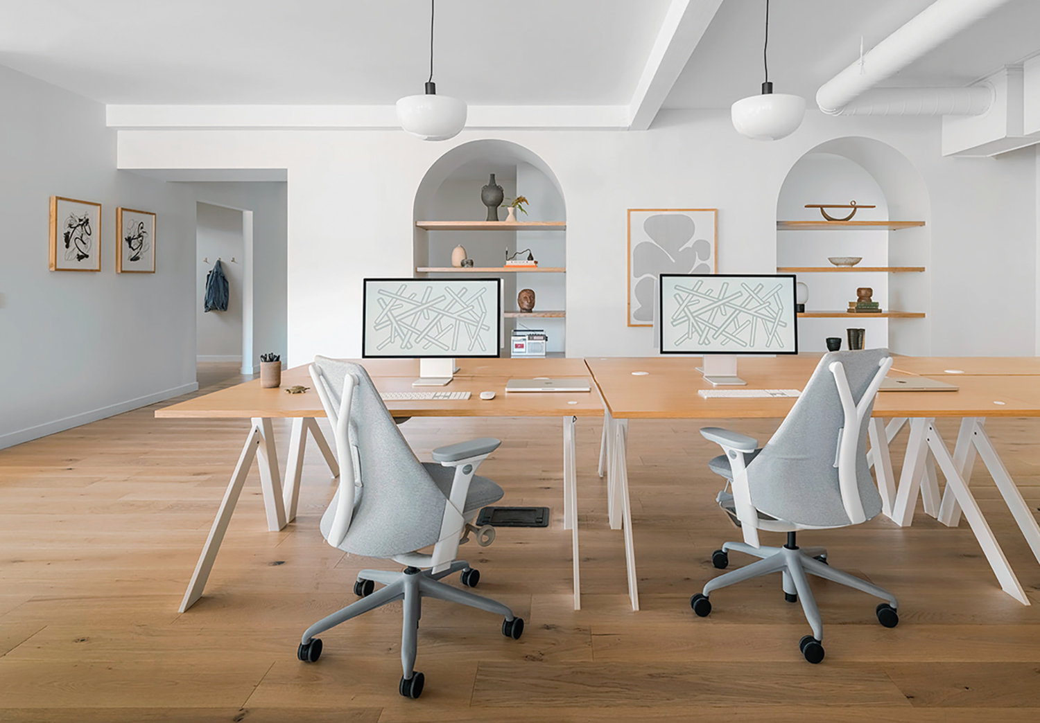 A room with a desk, chairs, and a computer.