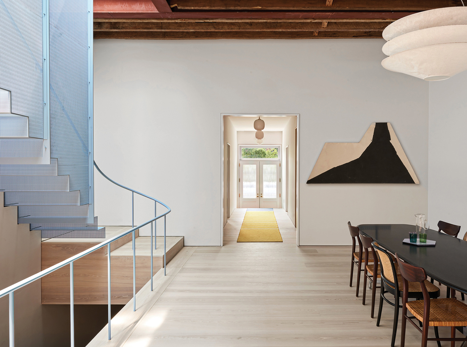 A long table sitting in a room next to a staircase.