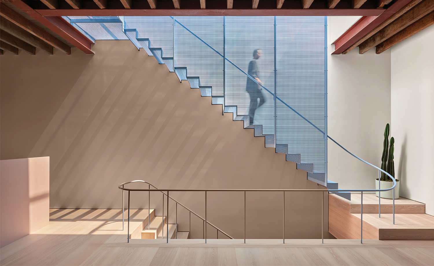 A staircase with a glass railing and a metal handrail.