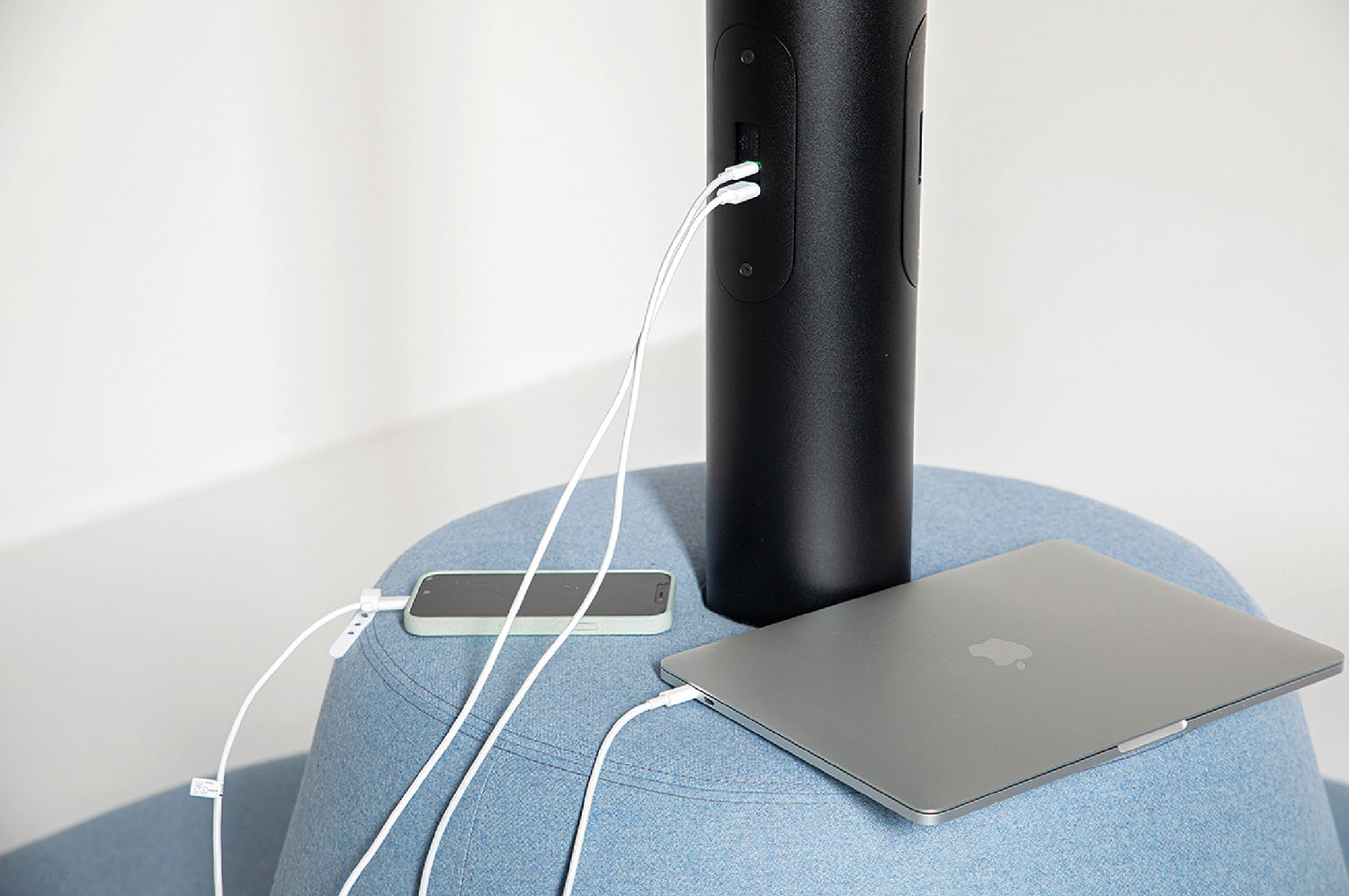 A laptop and a phone on a blue stool.