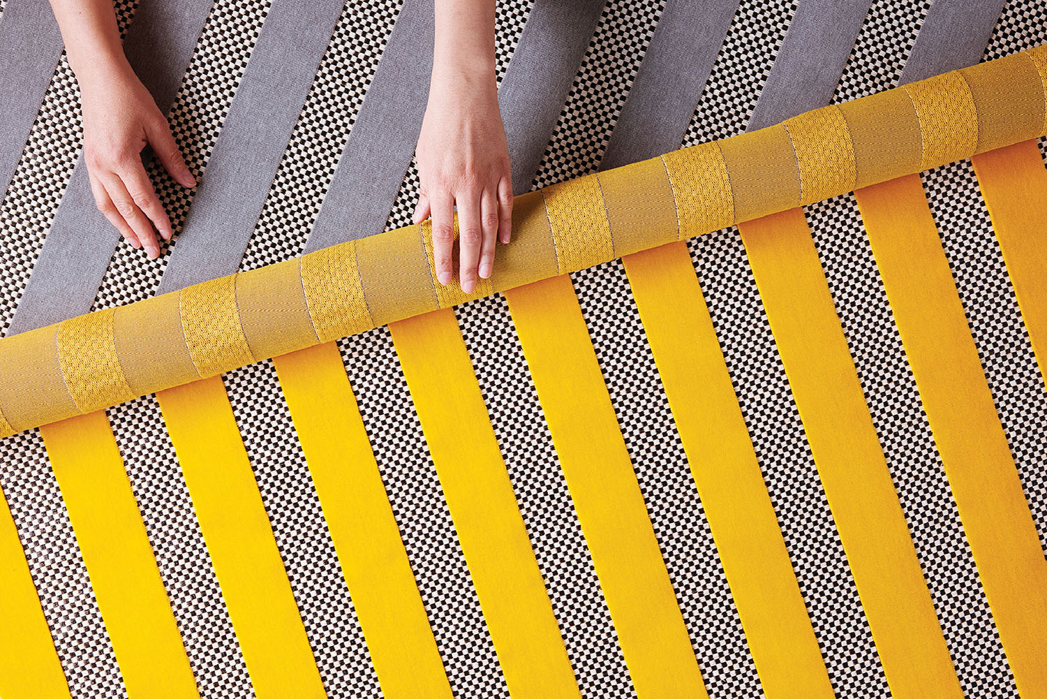 A person cutting a piece of yellow tape.