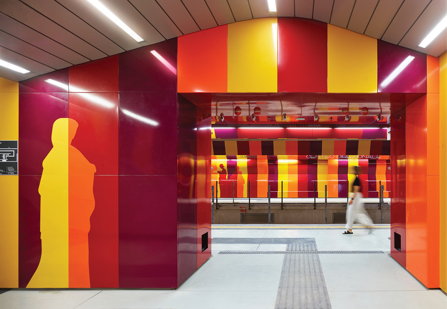 A colorfully painted hallway with a man walking through the door.