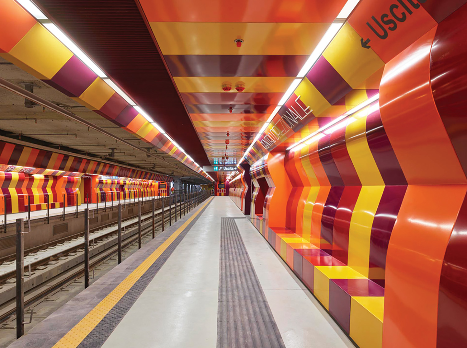 A train station with a long line of train cars.