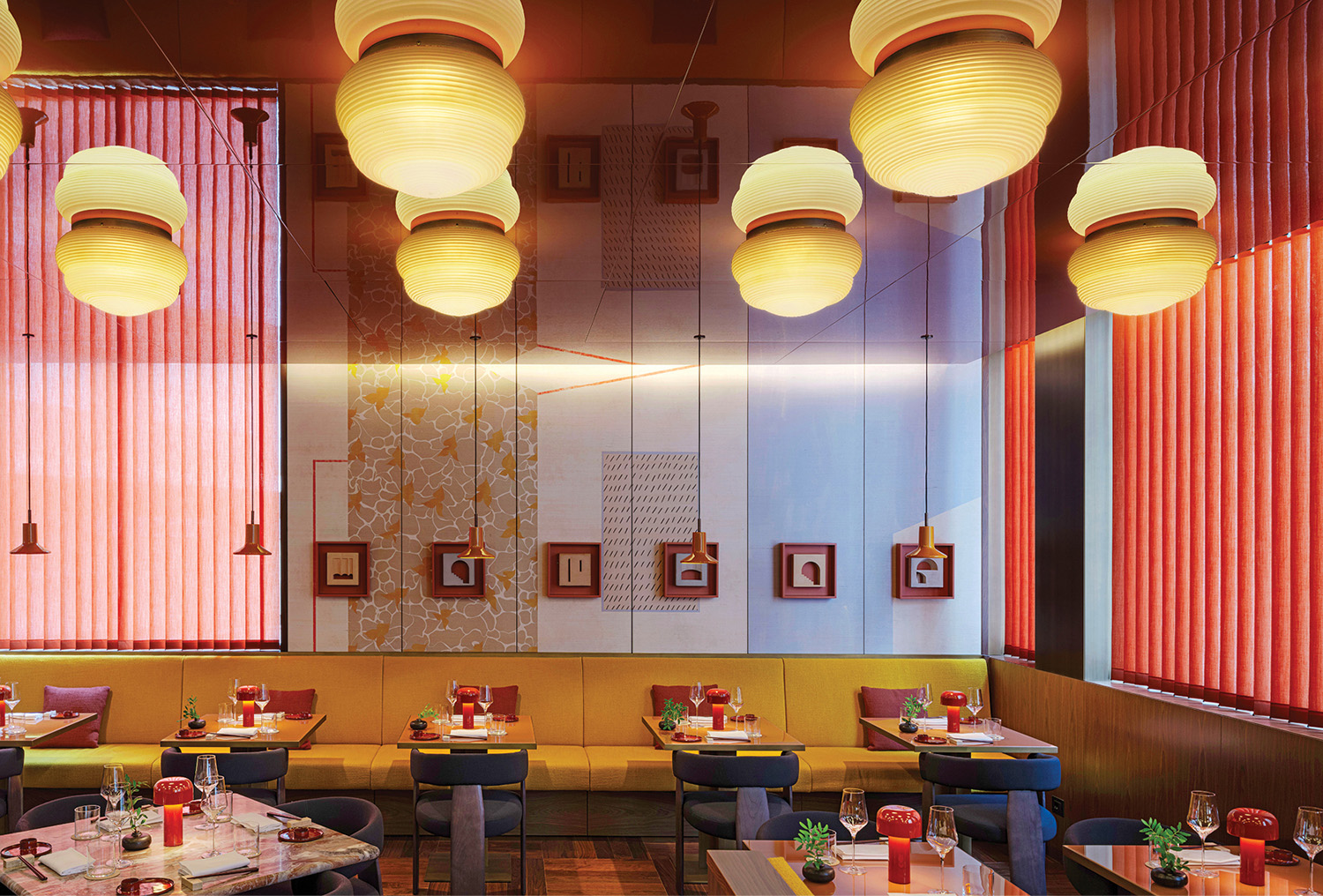 A restaurant with a table and chairs and a wall with red blinds.