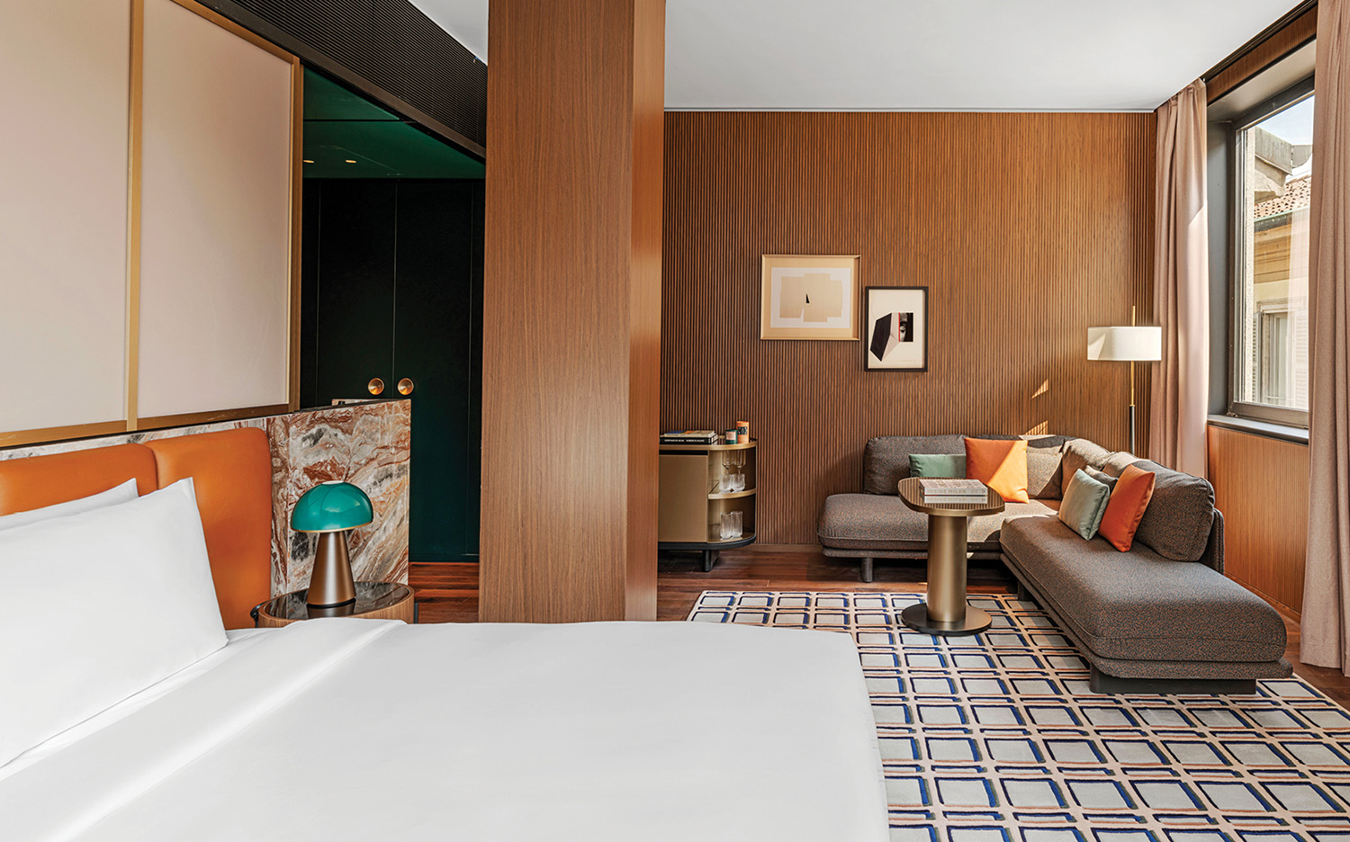 A hotel room with a bed, chair, and a couch.