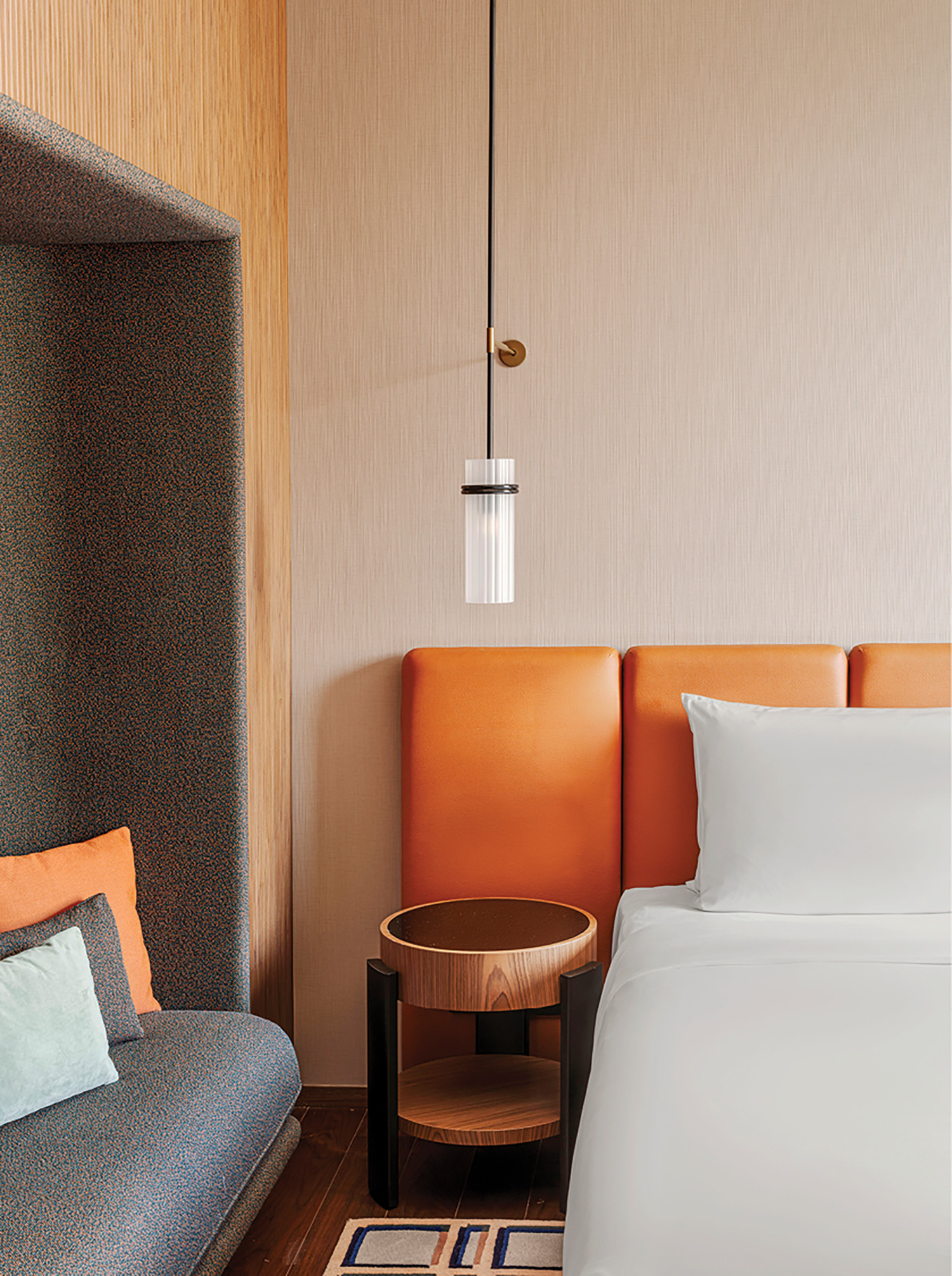 A bed with a blue and orange comforter.
