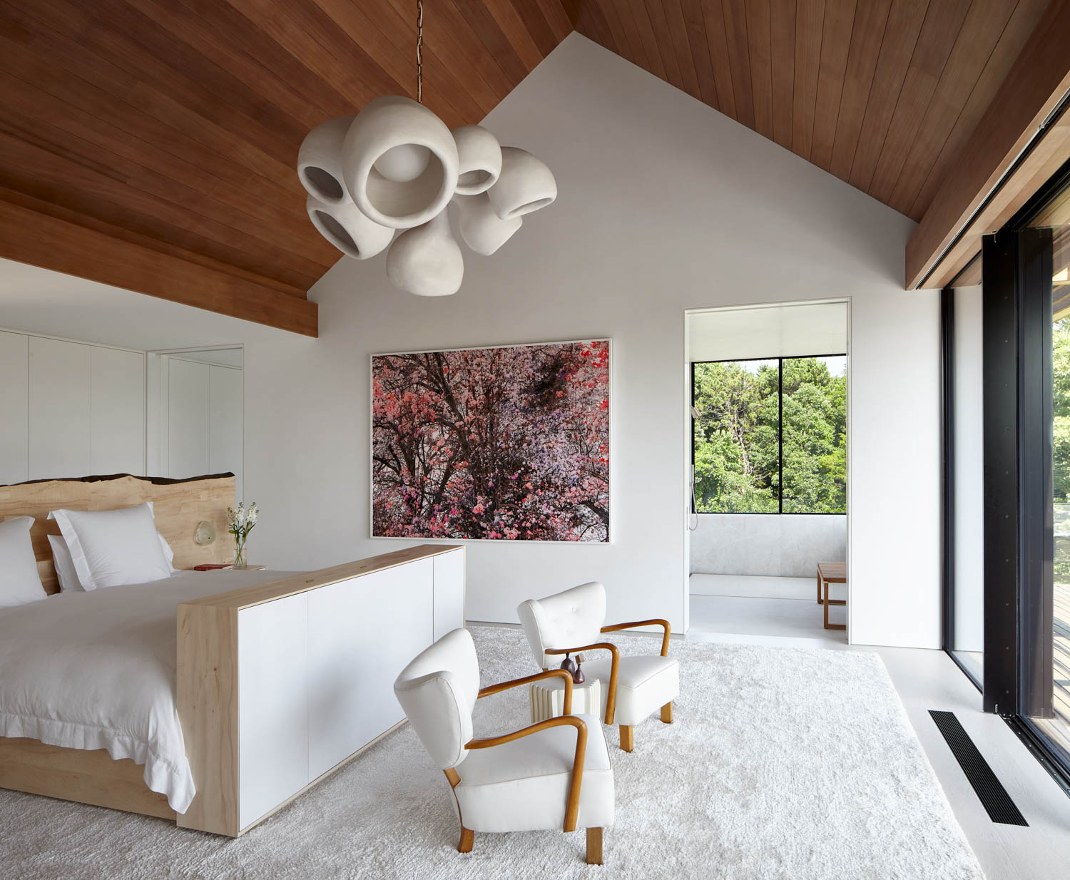bedroom with all white furnishings and gabled roof